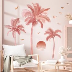 a living room with pink walls and palm trees on the wall, in front of a window