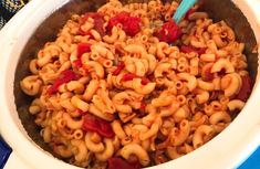 a bowl filled with macaroni and cheese sitting on top of a blue table