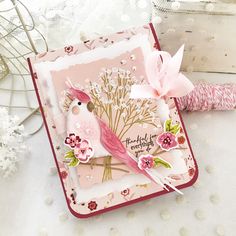 a close up of a card on a table with some flowers and scissors in it