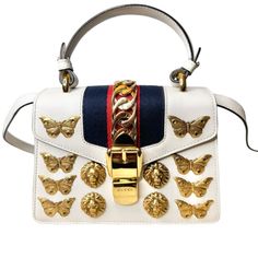 Color: White Description: Alessandro Michelle Designed A White Gucci Top Handle Bag Made Of Neutral Leather. This Is The Special Edition Gucci Animalier Sylvie Bag. This Gorgeous Bag Is Accented With Gold-Tone Hardware, A Flat Handle And A Single Adjustable Shoulder Strap. Additionally, It Has A Shiny Chain-Link Accent, Suede Lining, And A Single Interior Pocket. The Bag Opens Up With A Turn-Lock Closure At The Front. In Terms Of Its Overall Preowned Condition, It Has Been Slightly Used And In V Gucci Top Handle Bag, Gucci Top, Gucci Mini, Gorgeous Bags, Handle Bag, Bag Making, Chain Link, Top Handle, Top Handle Bag