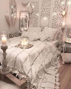 a white bedroom with candles on the bed