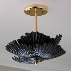 a black and gold chandelier hanging from the ceiling in a room with white walls