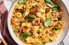 a pan filled with pasta and meat on top of a table