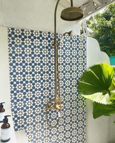 a shower head and hand held shower faucet in a bathroom with blue tiled walls