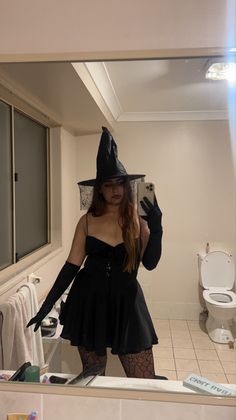 a woman in a witch costume is taking a selfie