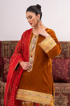 A traditional style suit in velvet with gota work on the neck and hem with handmade motifs on the neckline. Paired with a tailored shalwar and an emroidered organza dupatta for a sophisticated look.3-piece suitReady-to-wear Designer Red Unstitched Suit With Mirror Work, Festive Lawn Suit With Embroidered Border For Wedding, Festive Wedding Lawn Suit With Embroidered Border, Velvet Traditional Wear With Zari Work For Eid, Designer Red Churidar With Embroidered Border, Elegant Gold Salwar Kameez With Embroidered Border, Elegant Velvet Salwar Kameez For Festive Occasions, Elegant Velvet Salwar Kameez For Diwali, Semi-stitched Red Suit With Mirror Work