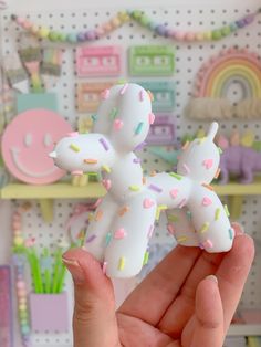 a person holding up a toy dog made out of sprinkles