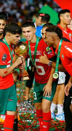 the soccer players are holding their trophy and confetti