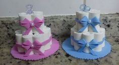 two cakes made to look like toilet paper with bows on the top, and one decorated as a cake