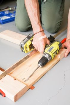 a man using a power drill to cut wood planks with a pair of screwdrivers