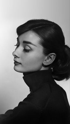 a black and white photo of a woman with her hair in a high pony tail