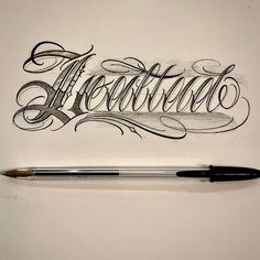 a pen sitting on top of a piece of paper with the word artifica written in cursive writing