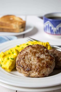 two hamburger patties and scrambled eggs on a plate