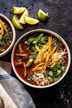 two bowls of chili soup with limes on the side