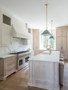 a large kitchen with an island, stove and oven in it's center area