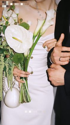 a bride and groom holding flowers in their hands