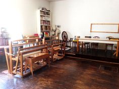 a room filled with wooden chairs and tables next to a book shelf full of books