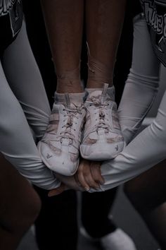 several people in white and black outfits hold their hands together