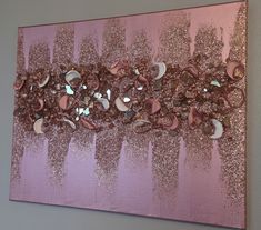 an abstract painting with pink and gold glitters on it's edges, along with seashells