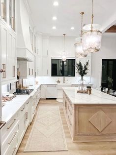 a large kitchen with white cabinets and marble counter tops, along with an area rug on the floor