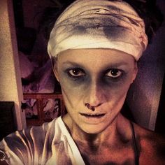 a woman with white makeup and bandages on her head