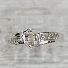 a white gold diamond ring with filigree accents