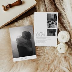 the wedding announcement is displayed next to an open book and flowers on a fur rug