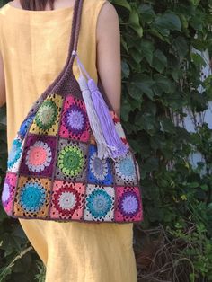 a woman is carrying a crocheted bag