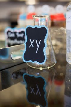 a table topped with bottles filled with water and writing on the side of each bottle