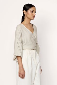 Introducing our V-Neck Wrap Blouse, a sophisticated and versatile top that transitions easily from day to night. Crafted from Japanese moss crepe with a luxurious finish, this blouse exudes effortless style. Pair it elegantly tucked into our Boyfriend Trouser for an effortless and coordinated look. Made with 100% Japanese Moss Crepe Handmade in IndiaMachine wash cold, lay flat to dry, warm iron as needed. Honoring Earth + Maker Our wovens are handcrafted in India, preserving age-old textile trad Boyfriend Trousers, Sustainable Knitwear, Rains Long Jacket, Denim Hat, Handmade Beauty Products, Organic Linens, Day To Night, Neck Wrap, Wrap Blouse