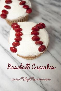 two cupcakes with white frosting and red berries on them are sitting on a marble surface