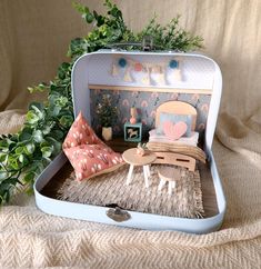 an open suitcase sitting on top of a bed next to a potted green plant