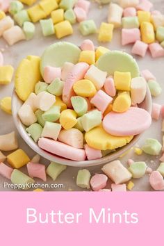 a spoon full of colorful marshmallows sitting on top of a white table