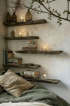 a bed with two shelves on the wall above it and candles in vases next to them