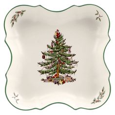 a white platter with a christmas tree on the bottom and green trimmings