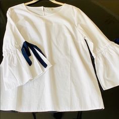 White Blouse With Navy Bow Tie Bell Sleeves. Never Worn. Originally $88. 100% Cotton. Pit To Pit Is About 20inches Shoulder To Hem Is About 24 Inches Posted 06.14.2019 Chic White Blouse With Tie Sleeves, White Blouse With Tie Sleeves For Daywear, White Long Sleeve Blouse With Tie Sleeves, Chic Shirt With Tie Sleeves For Spring, White Tie Sleeves Blouse For Office, Casual Tie Sleeve Tops For Office, Casual Office Tops With Tie Sleeves, White Chic Tops With Tie Sleeves, Chic White Tops With Tie Sleeves