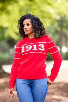 a woman wearing a red sweater and jeans