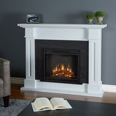 an open book sitting on top of a table next to a fire place in a fireplace