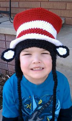 a young boy wearing a crocheted hat and smiling