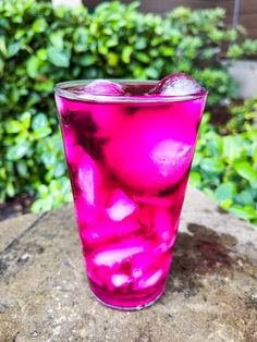 a pink drink sitting on top of a rock