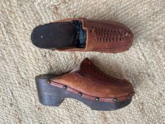 A really great pair of 1980s wood and leather clogs. They have a wooden sole with big brass studs, brown leather uppers, and a cool braided design at the toe. They are a classic slip-on style, very comfortable, and well-made. Condition: These have been well loved and worn but they do have a lot of life left in them still! Sole is in great condition aside from some small knicks and scratches. The leather is cracked and peeling but gives them a great worn in look. I would say that these are a size Vintage Brown Mules With Leather Footbed, Vintage Leather Clogs With Leather Footbed, Vintage Leather Mules With Leather Footbed, Vintage Brown Mules With Leather Sole, Vintage Leather Mules With Leather Sole, Retro Brown Leather Clogs, Vintage Brown Leather Mules, Vintage Clogs With Leather Sole And Closed Toe, Vintage Mules With Leather Sole And Round Toe