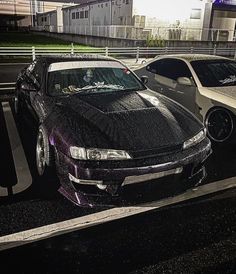 two cars parked next to each other in a parking lot covered in black and purple paint