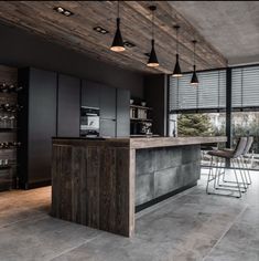 a modern kitchen with an island counter and bar stools