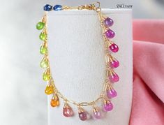 Embrace the magic with our Chasing the Rainbow Bracelet! This exquisite 14K Gold bracelet features sparkling drops of multi-colored Sapphires, capturing the enchanting hues of a radiant rainbow. Delicately crafted, the shimmering gemstones cascade around your wrist, symbolizing everlasting love and hope. Click to discover more! #HandmadeJewelry #SapphireBracelet #GoldJewelry #RainbowJewelry #SummerJewelry #ElegantJewelry Multicolor Gold Bracelet With Gemstones, Multicolor Gold Bangle Bracelet As A Gift, Multicolor Bangle Gold Bracelet As A Gift, Multicolor Multi-stone Gold Bracelet As Gift, Rainbow Multi-stone Bracelets As A Gift, Elegant Rainbow Faceted Jewelry, Elegant Rainbow Bracelets For Gifts, Elegant Rainbow Bracelets For Gift, Rainbow Multi-stone Bracelet