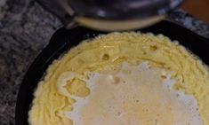 a pan filled with food sitting on top of a counter next to a frying pan