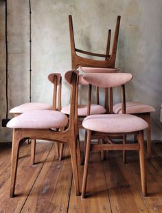 four chairs are stacked on top of each other in the middle of a wooden floor