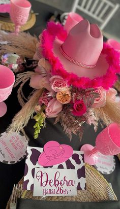 a pink hat is sitting on top of a table with place cards and napkins