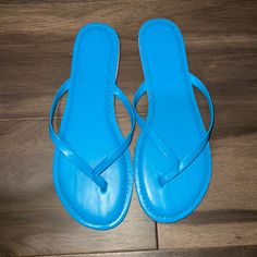 Never Worn. Blue Slip-on Summer Flip Flops, Casual Blue Sandals For Summer, Casual Blue Flip Flops For Summer, Light Blue Synthetic Flat Flip Flops, Blue Slip-on Flip Flops For Beach Season, Casual Light Blue Synthetic Flip Flops, Light Blue Flat Flip Flops For Summer, Light Blue Sandals With Round Toe For Beach, Light Blue Round Toe Sandals For Beach