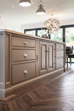 a large kitchen with an island in the middle and lots of cabinets on both sides