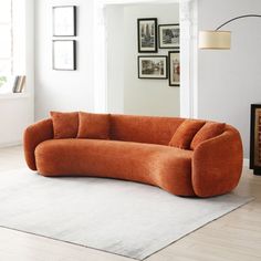 an orange couch sitting on top of a white rug